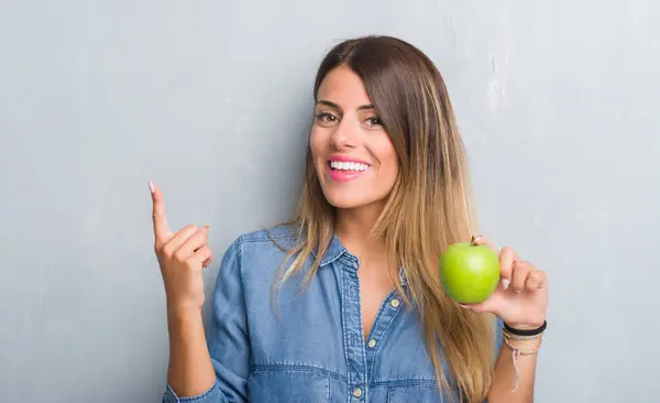 Joven Mujer Adulta Sobre Pared Grunge Gris Comiendo Manzana Verde —  Fotos de Stock