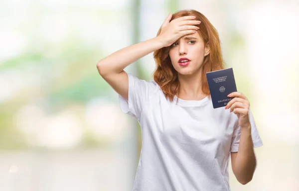 Young beautiful woman holding passport of germany over isolated background stressed with hand on head, shocked with shame and surprise face, angry and frustrated. Fear and upset for mistake.