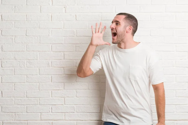 Young Caucasian Man Standing White Brick Wall Shouting Screaming Loud — Stock Photo, Image