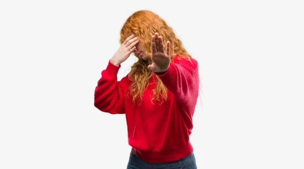 赤いセーターのカバーを身に着けている若い赤毛の女性両手目と悲しいとジェスチャーし恐れて停止を行う式 恥ずかしいと負の概念 — ストック写真