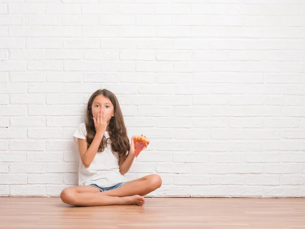 間違い 沈黙の中 秘密の概念で怖いの表現のための恥とショックを受けた手でピザ スライス カバー口を食べる白いレンガの壁に 床に座って若いヒスパニックの子供 — ストック写真
