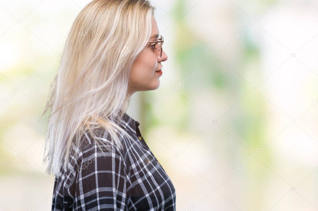 Young blonde woman wearing sunglasses over isolated background looking to side, relax profile pose with natural face with confident smile.