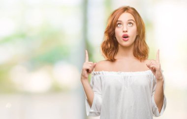 Genç güzel kadın izole arka plan üzerinden hayran ve yukarıya bakıp parmakları ile işaret şaşırttı ve silah kaldırdı.