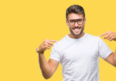 Yüzünde gülümseme ile kendinden emin görünüyorsun, kendini gururlu ve mutlu parmakları ile işaret izole arka plan üzerinde gözlük takan genç yakışıklı adam.