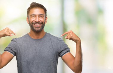Yüzünde gülümseme ile kendinden emin görünüyorsun, kendini gururlu ve mutlu parmakları ile işaret izole arka plan yetişkin İspanyol adam.