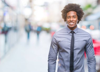 Yüzünde mutlu ve güzel bir gülümseme ile izole arka plan üzerinde Afro Amerikalı iş adamı. Şanslı kişi.
