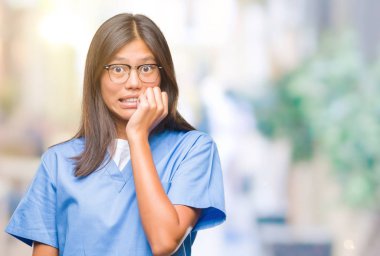 Genç Asyalı doktor kadın yüzünden stresli ve gergin elle çivi ısırma ağzına bakarak izole arka plan. Anksiyete sorunu.