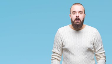 Genç beyaz hipster adam giyen kış kazak korkuyor ve şok sürpriz ifade ile izole arka plan üzerinde korku ve yüz heyecanlı.