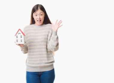 Gerçek durum Aracısı kadın evi çok mutlu ve heyecanlı, kazanan ifade ile çığlık zaferini kutluyor büyük holding izole arka plan yüzünden gülümseme ve ellerini kaldırdı genç Çince