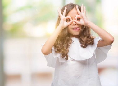 Esmer Latin kız dilini, parmaklarının arasından baktığını yapışmasını dürbün gibi ok jest yapıyor. Deli ifade.