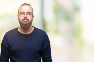 Genç beyaz hipster adam yüzünde ciddi bir ifade ile izole arka plan üzerinde güneş gözlüğü takıyor. Basit ve doğal kameraya bakıyor.