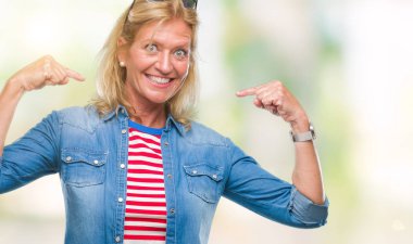 Yüzünde gülümseme ile kendinden emin görünüyorsun, kendini gururlu ve mutlu parmakları ile işaret izole arka plan orta yaş sarışın kadın.