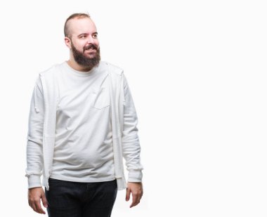 Spor kıyafetlerle üzerinde genç beyaz hipster adam arka plan uzak tarafına gülümseme ile yüzünde, doğal ifade arıyorum izole. Kendine güvenen gülüyor.