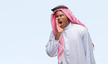 Geleneksel keffiyeh bağırarak ve ağzı üzerinde el ile yan için çığlık izole arka plan üzerinde giyen genç Arapça Afrika adam. İletişim kavramı.