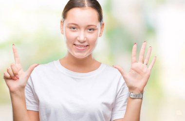 Genç güzel beyaz kadın gösterilen ve parmakları ile işaret izole arka plan yüzünden kendinden emin ve mutlu gülümseyerek süre yedi numara.