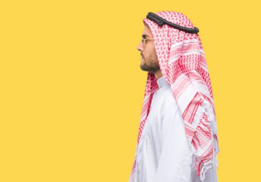 Genç yakışıklı adam giyen keffiyeh izole arka tarafına, seyir üzerinde dinlenmek doğal yüz emin gülümseme ile pozuyla profili.
