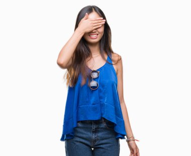 Genç Asyalı kadın gülümsüyor ve gözleri için sürpriz kapsayan yüz el ile gülüyor izole arka plan üzerinde. Kör kavramı.