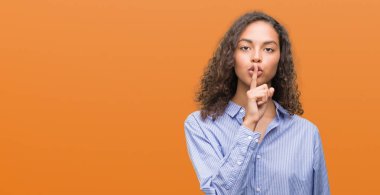 Dudaklarında parmak ile sessiz olmanı genç İspanyol iş kadını. Sessizlik ve gizli kavramı.