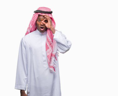 Sürpriz yüz, göz parmaklarının arasından seyir ile geleneksel keffiyeh ok jest yapıyor izole arka plan üzerinde giyen genç Arapça Afrika adam şok. İmansız ifade.