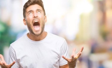 Genç yakışıklı adam izole arka plan çılgın ve kızgın bağırarak ve agresif ifade ve silah kaldırdı bağırıyor. Hayal kırıklığı kavramı.