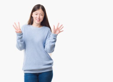 Gösterilen ve parmakları ile işaret izole arka plan üzerinde Genç Çinli kadın kendinden emin ve mutlu gülümseyerek süre sekiz numara.