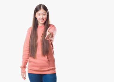 Genç Çinli kadın dostu sunan karşılıklı tebrik ve davet edici gülümseyen spor sweathshirt giyen arka plan izole. Başarılı iş.