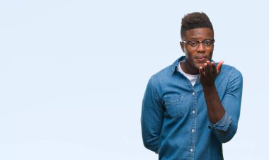 Afrikalı-Amerikalı genç bir öpücük el ile güzel ve seksi olmak hava üfleme kamera bakarak izole arka plan üzerinde. Aşk ifade.