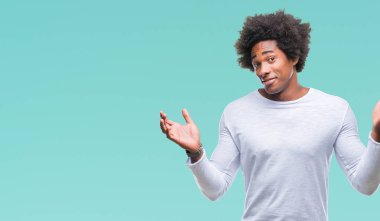 İzole arka plan clueless ve şaşkın bir ifadeyle kollar ve eller kaldırdı Afro Amerikan adam. Şüphe kavramı.