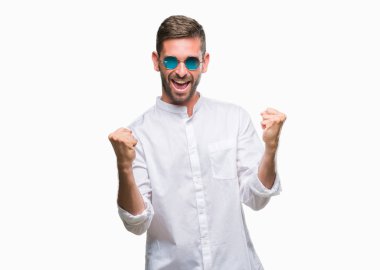 Gülümseyen ve başarı için çığlık izole arka plan çok mutlu ve heyecanlı kaldırdı, silah ile kazanan jest yapıyor üzerinde gözlük takan yakışıklı delikanlı. Kutlama kavramı.