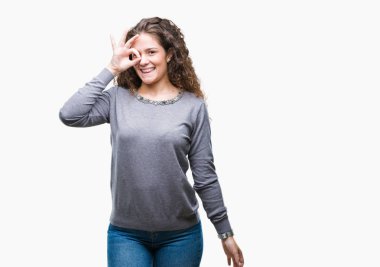 Güzel esmer kıvırcık saçlı Genç kız gülümsüyor, parmakları ile mutlu yüz üzerinden seyir göz el ile ok jest yapıyor izole arka plan üzerinde bir kazak giyiyor.