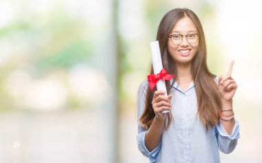 Genç Asyalı kadın holding derecesi üzerinde arka plan ile bir fikir ya da gülen yüz, bir numara ile parmak işaret soru sürpriz izole