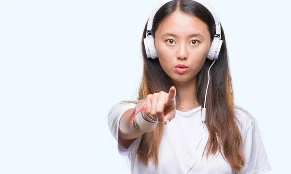 Young Asian Woman Listening Music Wearing Headphones Isolated Background Pointing — Stock Photo, Image