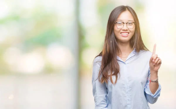 眼鏡をかけて分離背景表示と指番号のいずれかニコニコしながら自信を持って 幸せを上向きに若いアジア ビジネス女性 — ストック写真