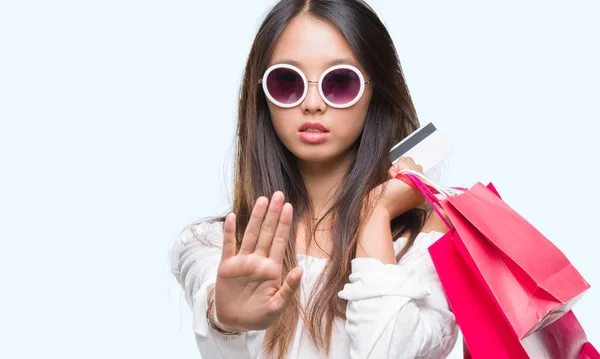 防衛ジェスチャー 深刻な自信を持って式に一時停止の標識を行うオープンの手で隔離された背景の上ショッピング バッグ販売保持若いアジア女性 — ストック写真