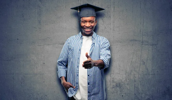 Young african graduate student black man holds hands welcoming in handshake pose, expressing trust and success concept, greeting