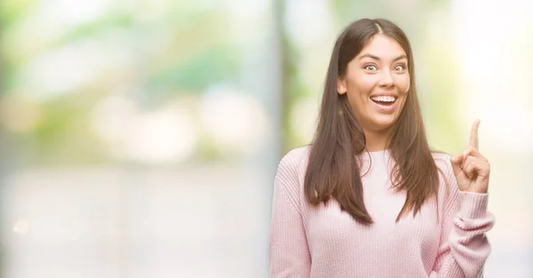 年轻漂亮的西班牙裔妇女穿着一件毛衣 指着成功的想法 退出和快乐 第一个 — 图库照片