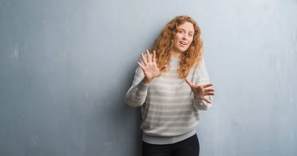 年轻的红头发的女人在灰色的垃圾墙上害怕和恐惧的表情 用手停止手势 震惊地大叫 恐慌概念 — 图库照片