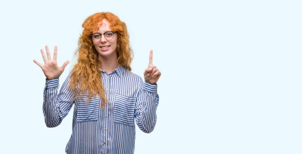 若い赤毛のタマン女性を示すと指で上向きナンバー 自信を持って 幸せな笑みを浮かべて — ストック写真