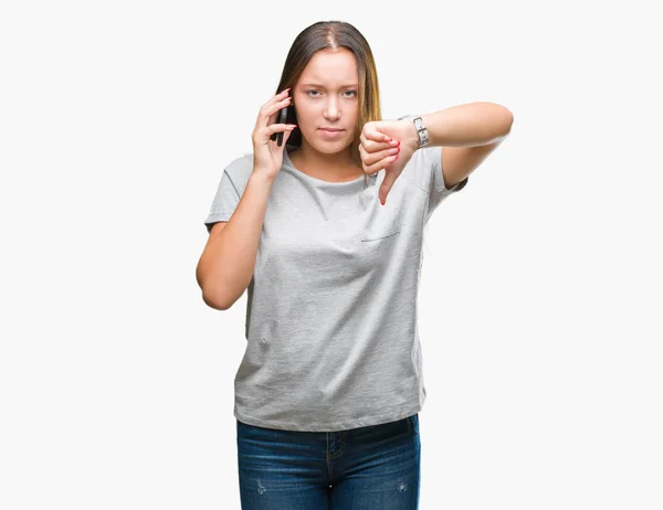怒った顔 ダウン親指で嫌悪感を示すマイナス記号 拒絶反応の概念と分離の背景にスマート フォンで話している若い美しい白人女性 — ストック写真
