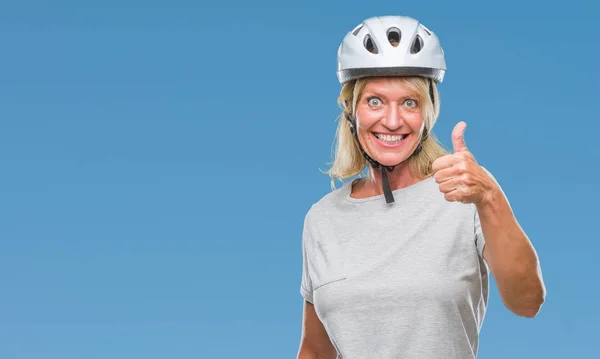 中年白人のサイクリストの女性がハッピー サムズアップ手でジェスチャーをして孤立した背景に安全ヘルメットを着用します 成功を示すと カメラを見て式を承認します — ストック写真