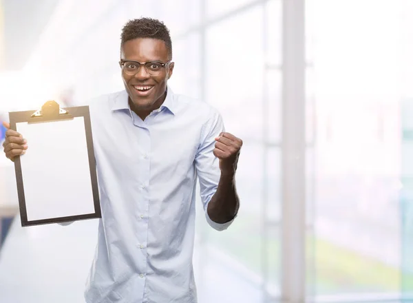 Jonge Afro Amerikaanse Man Houden Een Clipboarad Schreeuwen Trots Vieren — Stockfoto