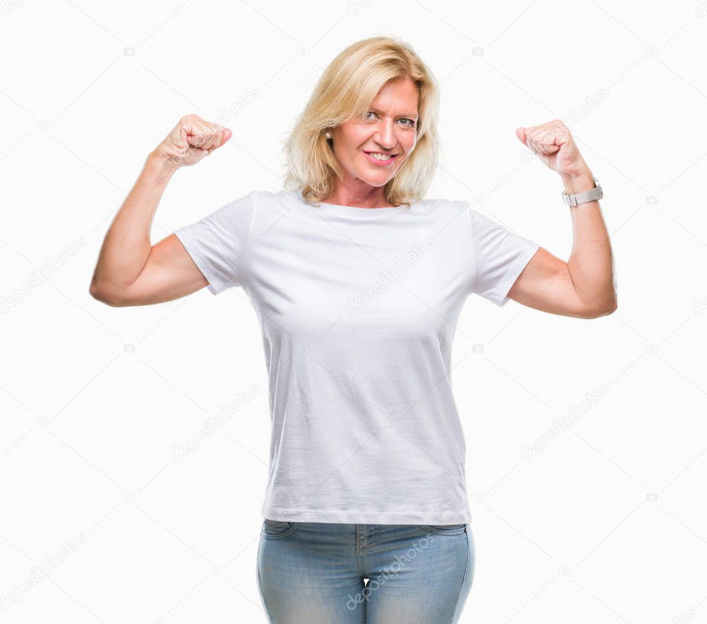 Middle age blonde woman over isolated background showing arms muscles smiling proud. Fitness concept.