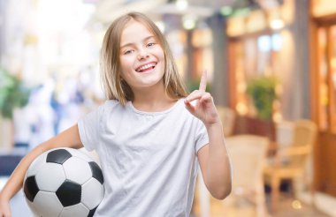 Futbol futbol topu izole arka plan üzerinde bir fikir ya da soru işaret parmağı gülen yüz, bir numara ile sürpriz tutan genç güzel kız