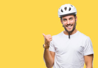 Yakışıklı delikanlı arıyor ve başparmak yanında yukarıyı mutlu yüz ile gülümseyen izole arka plan üzerinde bisikletçi Güvenlik kask giyiyor.