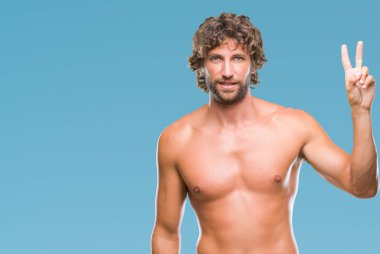 Yakışıklı İspanyol adam seksi model ve parmakları ile gülümseyen ise kendinden emin ve mutlu ve yukarıyı gösteren izole arka plan üzerinde gömleksiz ikincisi.