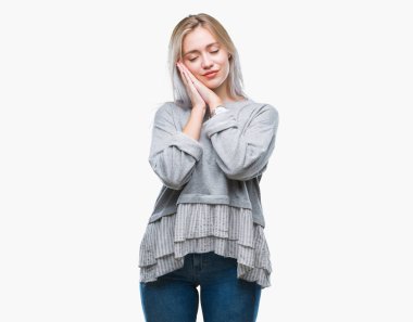 Genç Sarışın kadın yüzünden uyku yorgun hayal ve ellerle birlikte poz ile kapalı gözler gülümseyen izole arka plan.