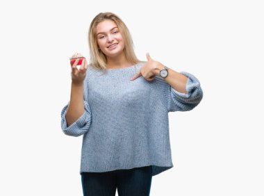 Sürpriz yüz işaret parmağı kendini izole arka plan üzerinde tatlı kek yeme genç kafkas kadın