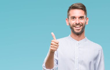 Yakışıklı delikanlı hareketi el ile mutlu yaşasın yapıyor izole arka plan üzerinde. Kameraya bakarak başarı gösteren ile ifade onaylama.