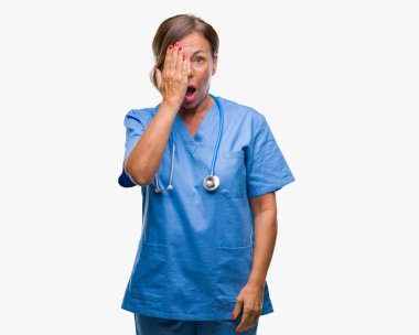 Orta yaş kıdemli hemşire doktor kadın el yüz ve sürpriz duygu kendinden emin gülümseme ile tek gözüyle kapsayan izole arka plan.