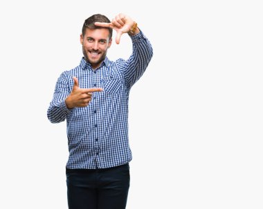 Yakışıklı delikanlı elle yapma çerçeve ve parmakları ile mutlu yüz gülümseyen izole arka plan üzerinde. Yaratıcılık ve Fotoğrafçılık kavramı.